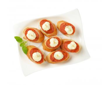 Bread based canapes with spicy sausage and creamy spread