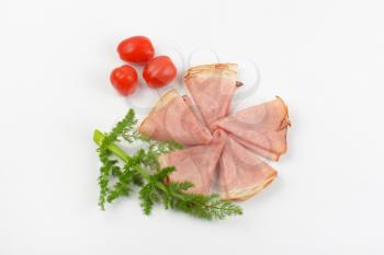 ham slices with fresh dill and cherry tomatoes on white background