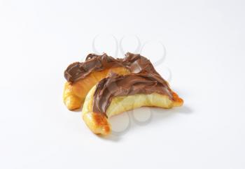 croissants topped with chocolate cream on white background