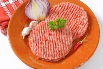 plate of raw hamburger patties - close up