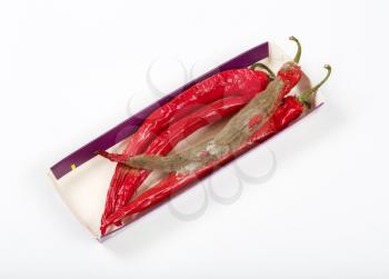 shrinking and mouldy chili peppers in paper box