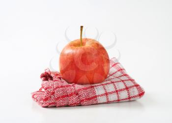 red ripe apple on checkered dishtowel