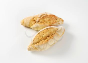 two diamond shaped rustic bread rolls on white background