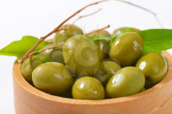 bowl of green olives on white background - close up