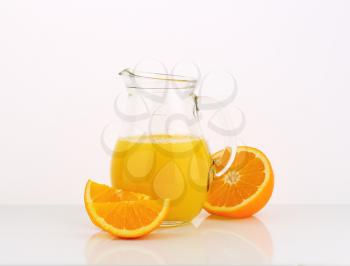 jug of fresh orange juice on white background