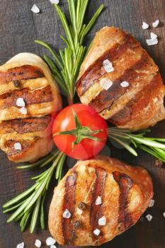 grilled pork medallions on wooden cutting board