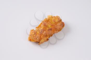 fried corn flake coated piece of chicken meat on white background