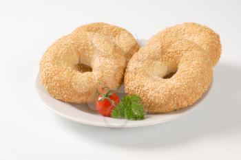 fresh bagels with sesame seeds on white plate
