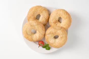 fresh bagels with sesame seeds on white plate