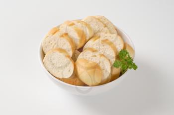 bowl of sliced french baguette on white background