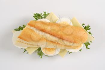 French bread sandwich with eggs and cheese on white background