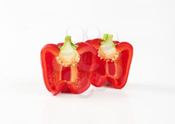 halved red bell pepper on white background