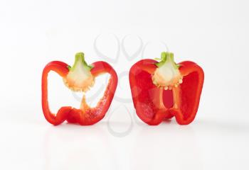red bell pepper half and slice on white background