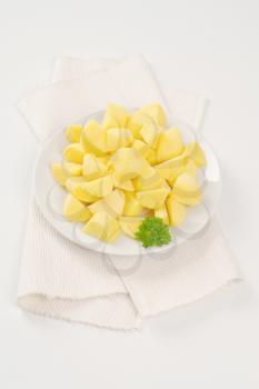 plate of raw diced potatoes on white place mat