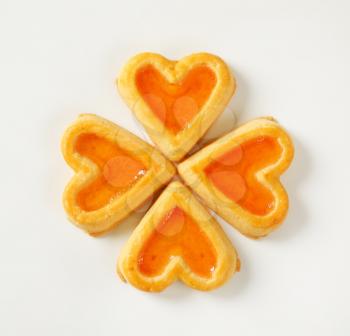 heart-shaped cookies with jam filling on white background