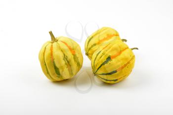 three small striped pumpkins on white background