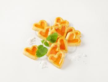 heart-shaped cookies with jam filling on white background