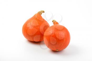 two small orange pumpkins on white background