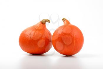 two small orange pumpkins on white background
