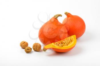orange pumpkins with walnuts on white background