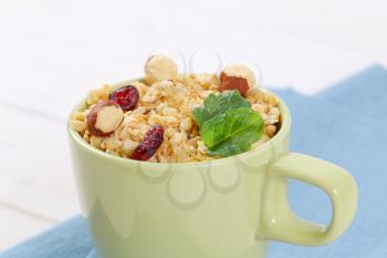 cup of granola with hazelnuts and dried cranberries - close up