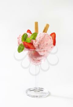 scoops of strawberry ice cream and fresh strawberries in cocktail glass