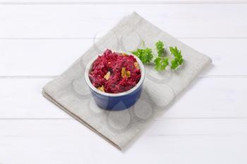 bowl of fresh beetroot spread with walnuts on beige place mat