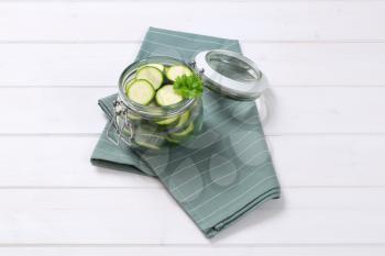 jar of green zucchini slices on grey place mat