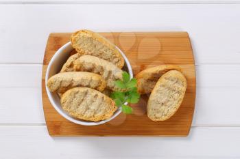 bowl of crispy rusks on wooden cutting board