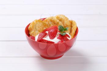 bowl of american pancakes with white yogurt and fresh strawberries on white wooden background