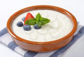 bowl of semolina pudding with fresh fruit on striped napkin - close up
