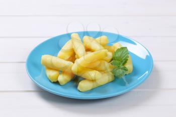plate of cooked potato cones or gnocchi on white wooden background