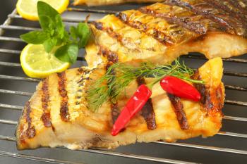 Grilled carp fillets on barbecue grill