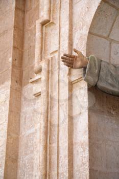 Detail of hand outstretched from a church alcove