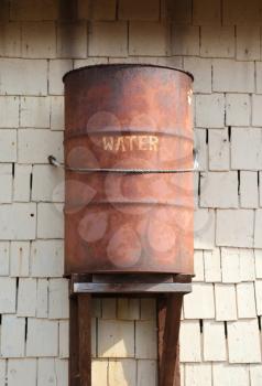 Old rusty rainwater barrel attached to house, Popeye village, Malta