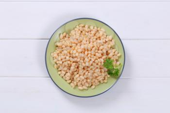 plate of canned white beans on white wooden background