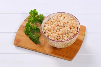 bowl of canned white beans on wooden cutting board
