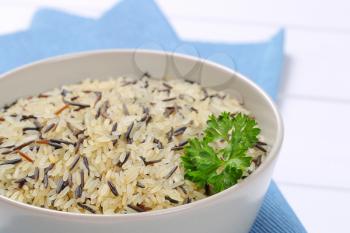 bowl of wild rice on blue place mat - close up