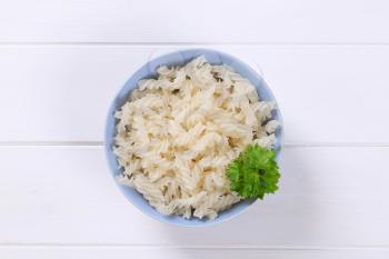 bowl of cooked rice pasta fusilli on white wooden background