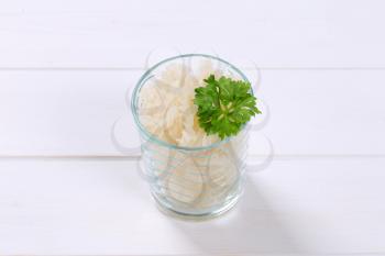 glass of cooked rice pasta fusilli on white wooden background