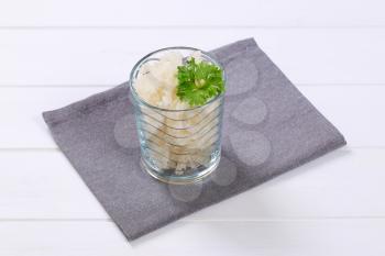 glass of cooked rice pasta fusilli on grey place mat