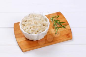 bowl of cooked rice pasta fusilli on wooden cutting board