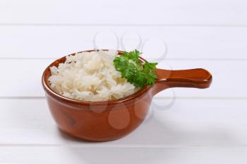 saucepan of cooked rice pasta fusilli on white wooden background