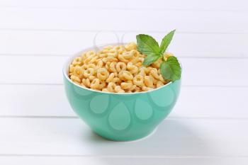 bowl of honey cereal rings on white wooden background