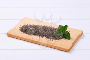 pile of chia seeds on wooden cutting board