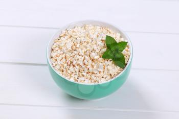 bowl of puffed buckwheat on white wooden background