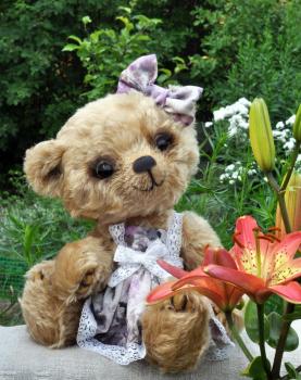 Handmade, the sewed toy: teddy-bear Lucky on a on an ancient linen cloth among flowers