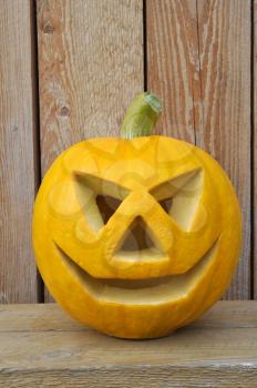 Symbol Halloween - a pumpkin  Lantern on a wooden bench against wooden boards..