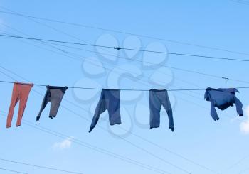 Laundry Washing Clothes, Old Pants and Shirt, Drying on a Rope against the Blue Sky