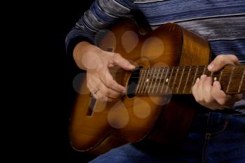 man playing classical guitar at black background
